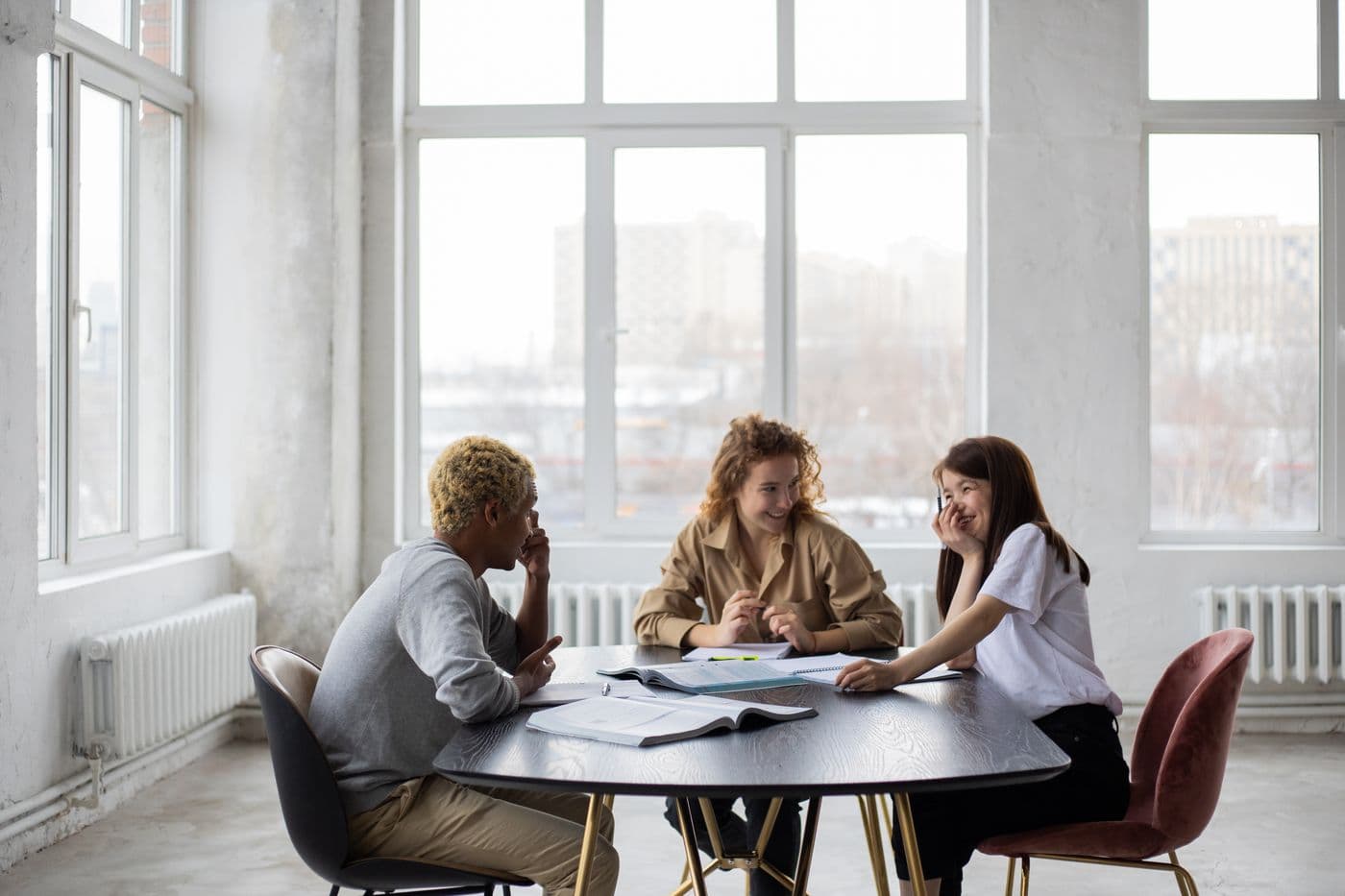 Three learners exchanging ideas around a table